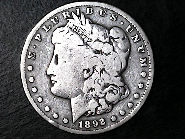 Silver Morgan Dollar Left-facing profile of Liberty wearing a Phrygian cap, with 'LIBERTY', "E PLURIBUS UNUM" and '1892' inscriptions on a black background with case