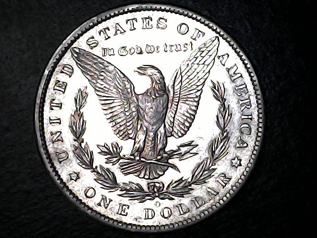 Silver dollar coin with an eagle design on a dark background