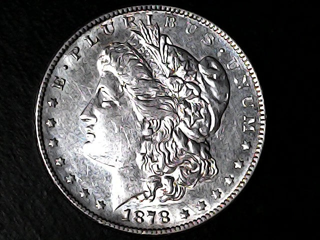 Silver Morgan Dollar Left-facing profile of Liberty wearing a Phrygian cap, with 'LIBERTY', "E PLURIBUS UNUM" and '1878' inscriptions on a black background with case