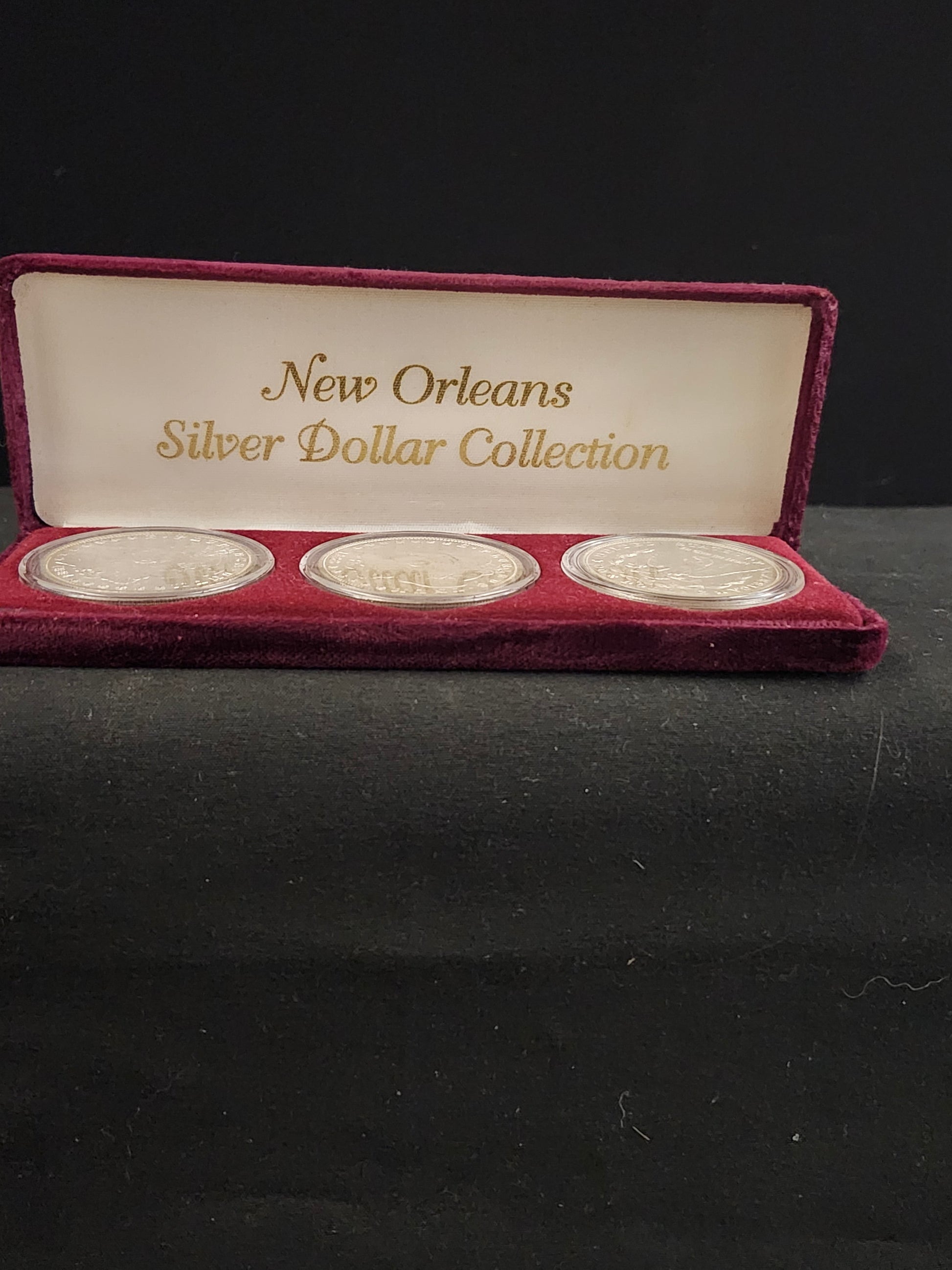 Set of New Orleans Silver Dollar Collection in a display case on a dark background