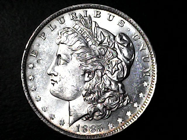 Silver coin with a profile of a head and inscriptions on a dark background