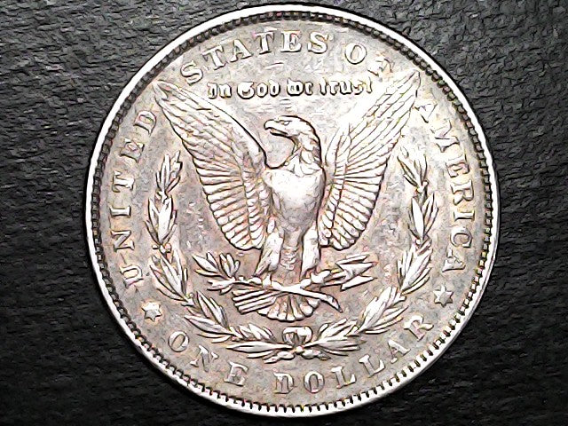 Silver Dollar with an eagle design and 'In God We Trust' inscription on a black background