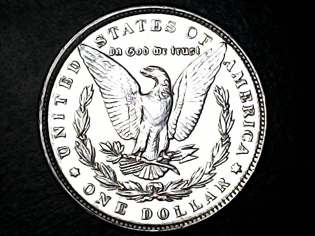 Silver dollar coin with an eagle emblem on a black background