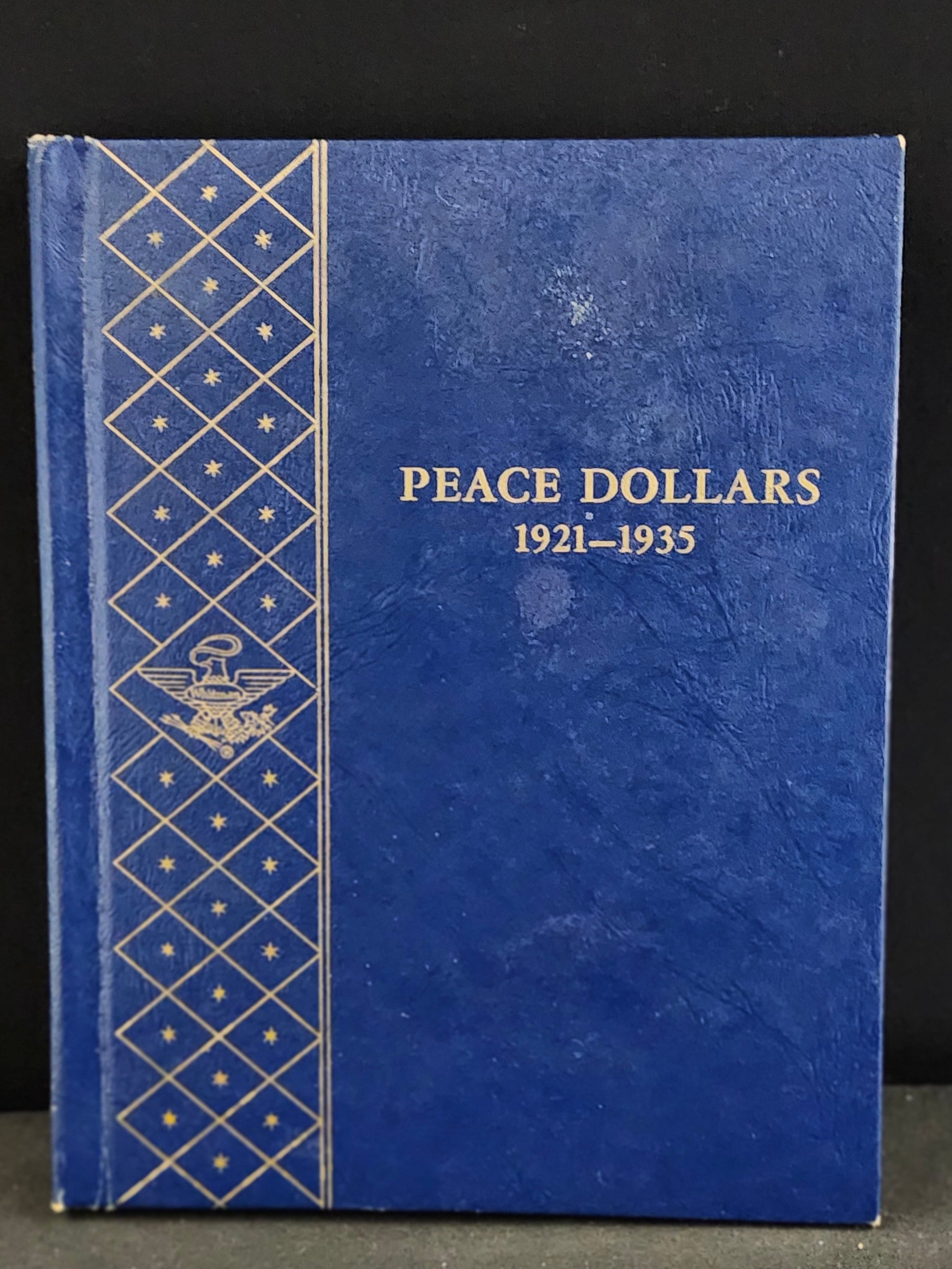 Blue album for Peace Dollars 1921-1935 on a dark background