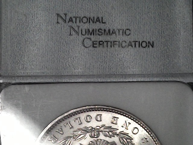 Silver coin in a holder with 'National Numismatic Certification' branding.