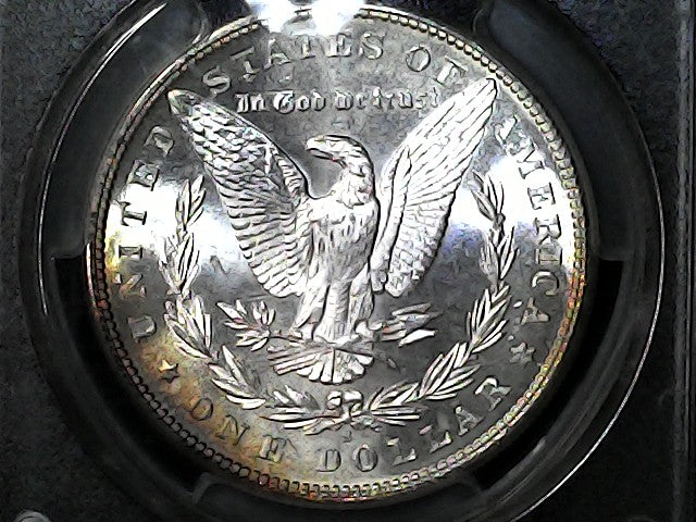 Silver dollar coin with an eagle design in a protective case.