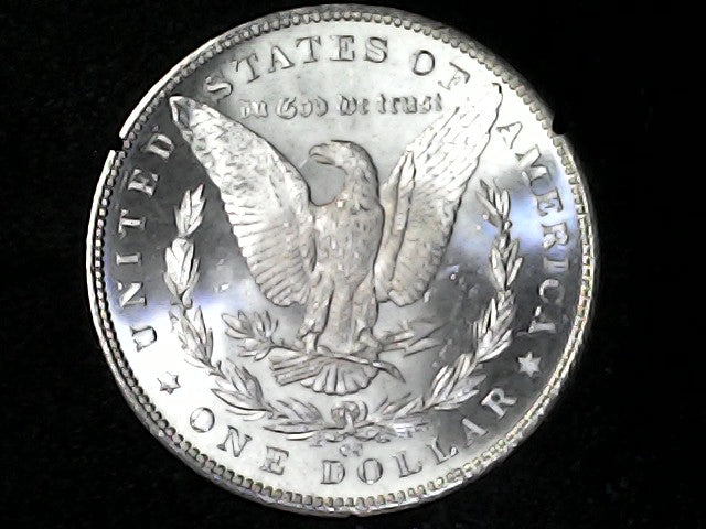 Silver dollar coin with an eagle design on a black background