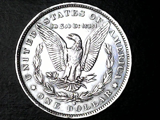 Silver Dollar with an eagle design, 'In God We Trust' and 'O' inscriptions on a black background 