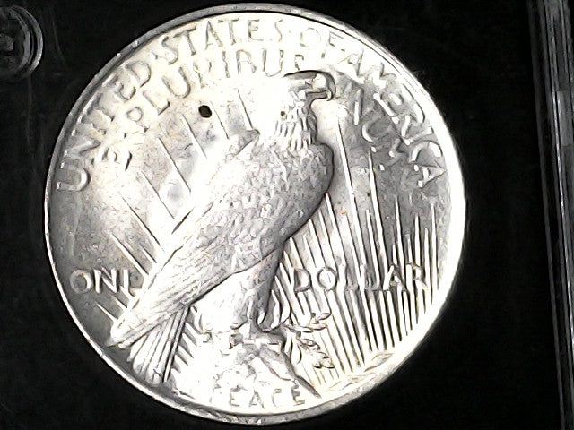 Silver dollar coin with an eagle design  with 'PEACE' inscription