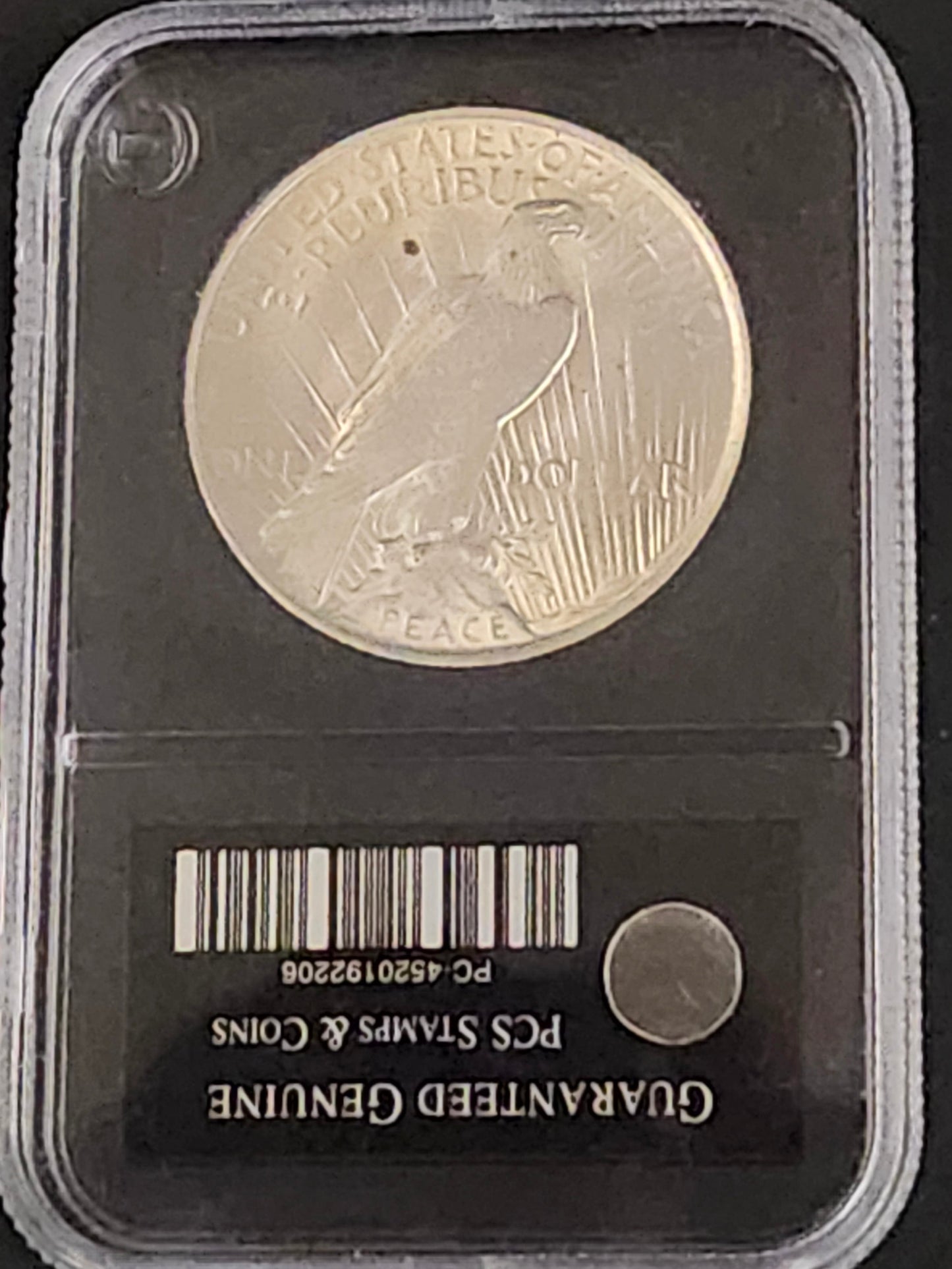 Silver Peace coin in a clear holder with a black background