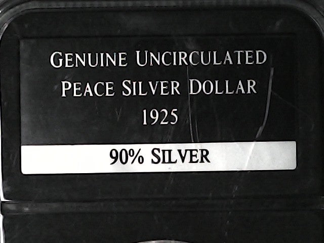 Label on a black background indicating a genuine uncirculated 1925 Peace Silver Dollar with 90% silver content.