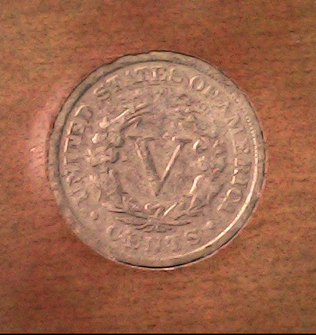 Silver coin with 'V' symbol