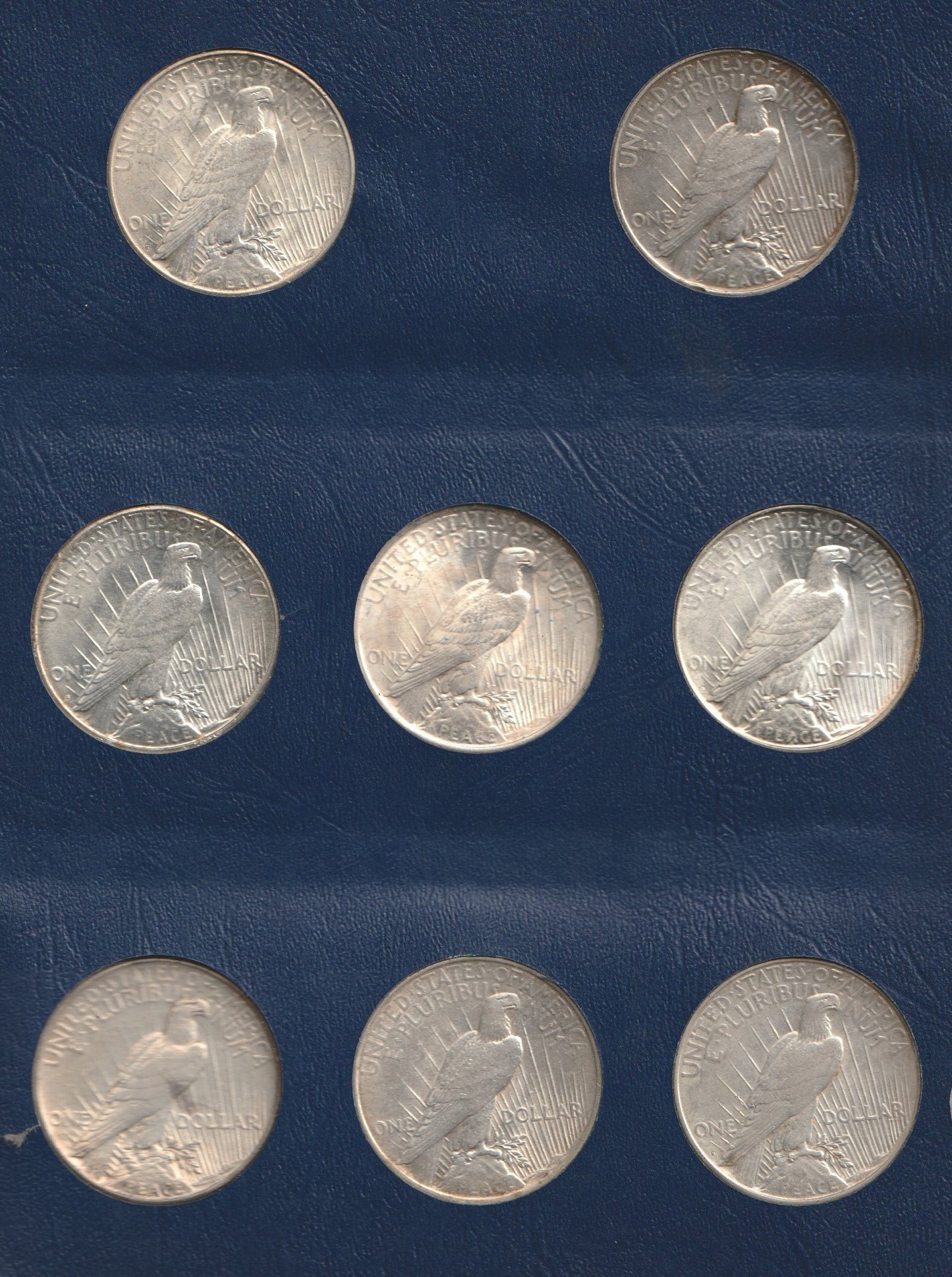 Collection of silver coins with an eagle design on a blue background